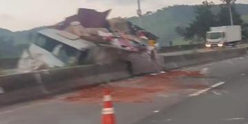 Em Cambuí carreta bate em veículo, atinge mureta e tomba na Fernão Dias